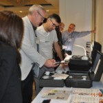 Professionals examine the Iris Vision device during a conference